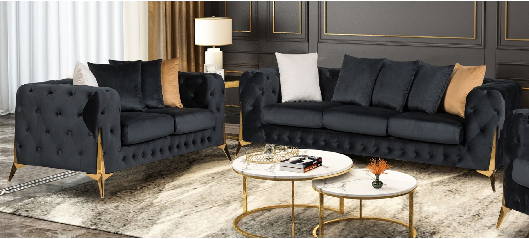 Two dark gray tufted sofas with gold legs in a room with a coffee table and decor.